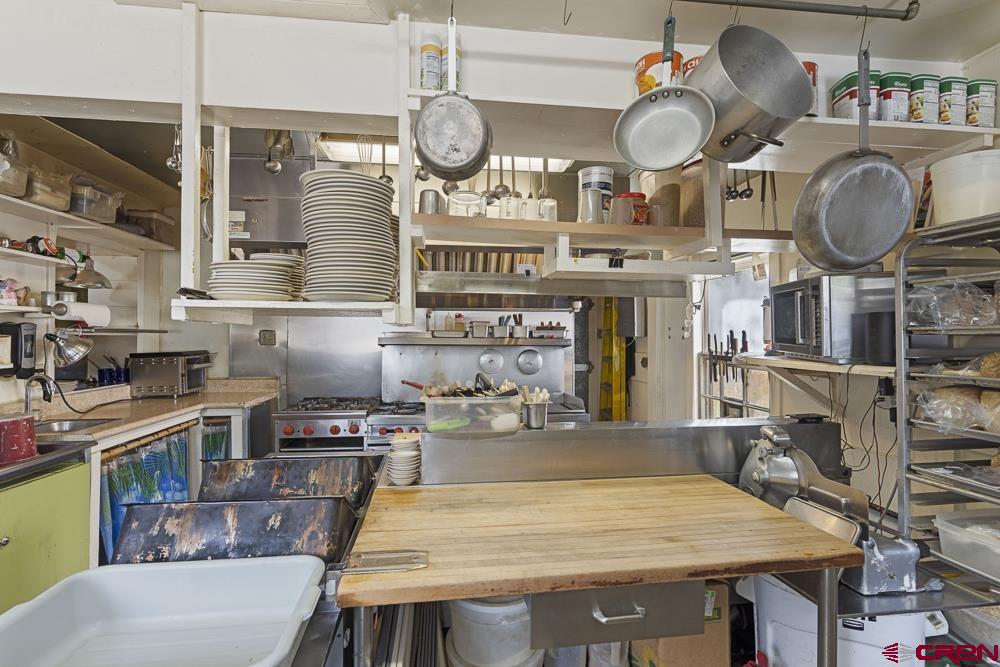 595 East 7th Avenue Durango, CO 81301 - Photo 10 of 34 a kitchen with stainless steel appliances granite countertop a stove a sink and a dining table with wooden floor