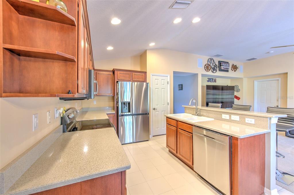 7352 Bridgeview Drive Zephyrhills, FL 33545 - Photo 19 of 49 a kitchen with stainless steel appliances granite countertop a sink a stove and a refrigerator