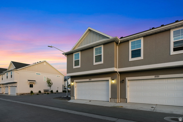 1223 East 1775 North Payson, UT 84651 - Photo 4 of 45 Contemporary townhome exterior featuring an attached two-car garage, stucco finish, and white-trimmed windows