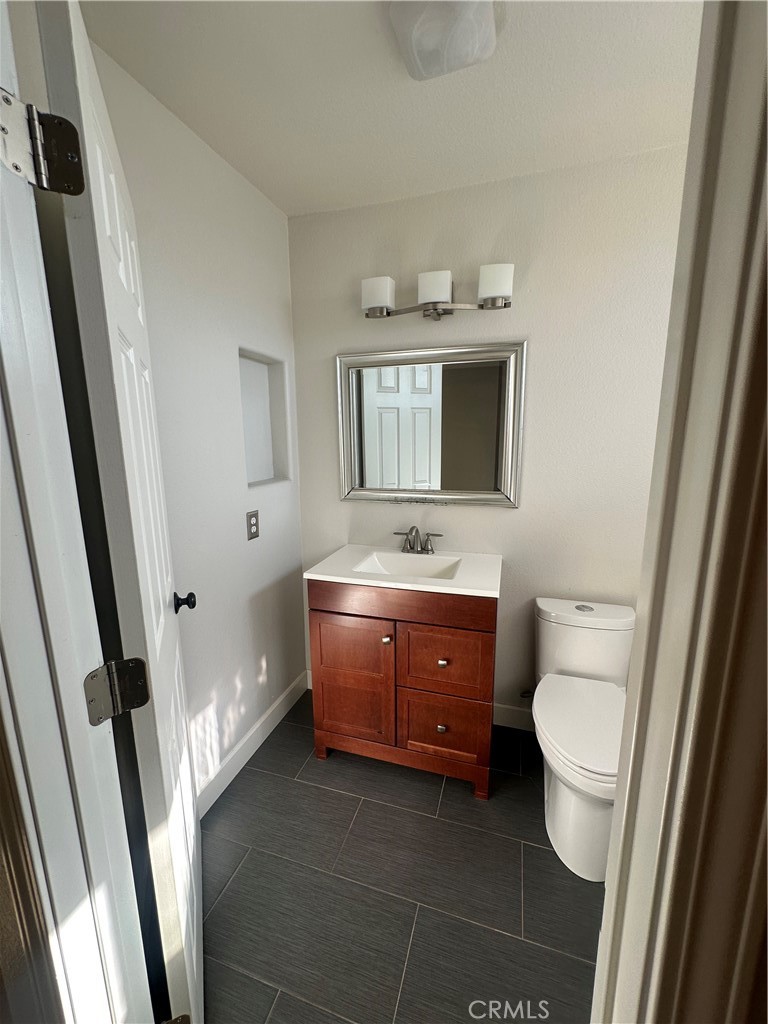 29652 Chandler Road Highland, CA 92346 - Photo 17 of 22 a bathroom with a granite countertop toilet sink and mirror