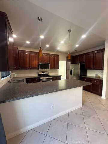 a large kitchen with a large counter top stainless steel appliances and cabinets