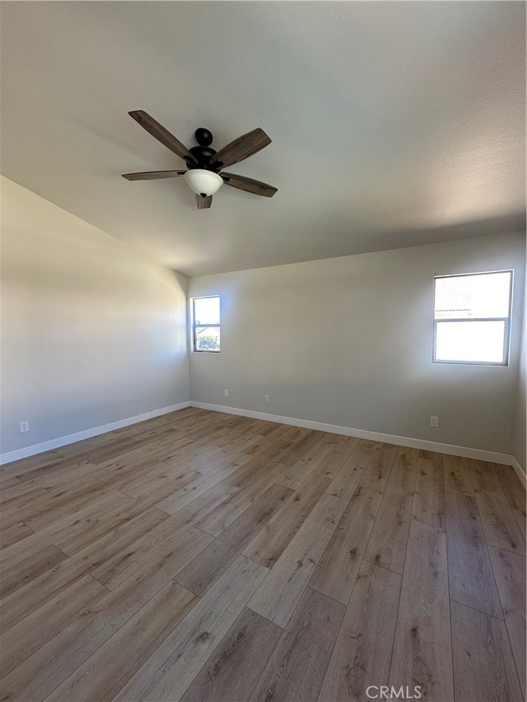 29652 Chandler Road Highland, CA 92346 - Photo 10 of 22 an empty room with wooden floor fan and windows