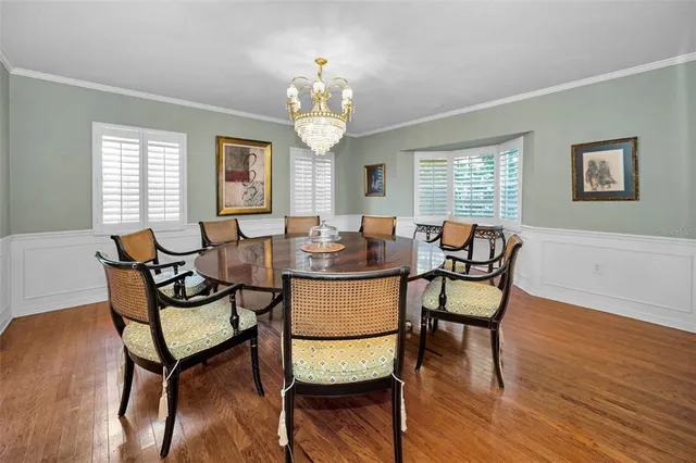 a dining room with furniture a chandelier and wooden floor
