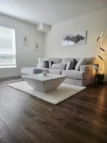 a living room with kitchen island furniture and a wooden floor