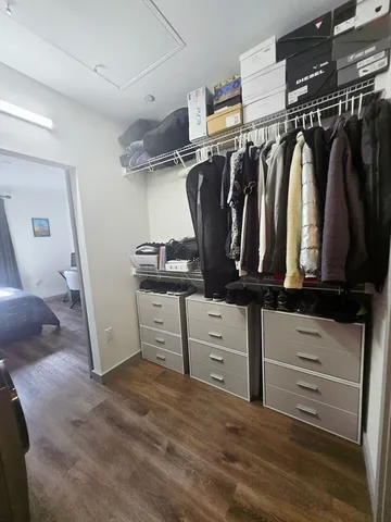 a view of walk in closet with clothes and shoes