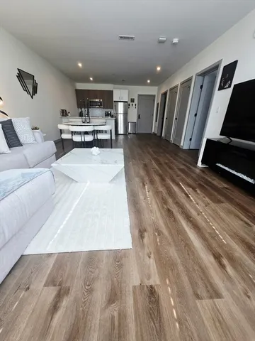a living room with stainless steel appliances kitchen island granite countertop furniture and a couch