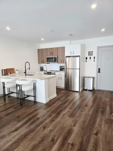 a kitchen with refrigerator and chairs