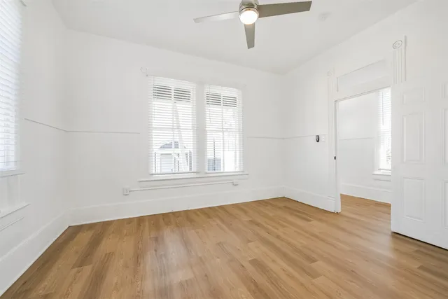 an empty room with a window and a ceiling fan