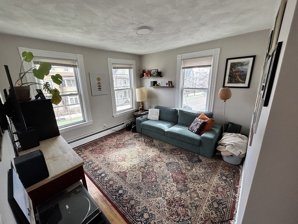 328 Beacon Street, Unit 2F Somerville, MA 02143 - Photo 1 of 6 a living room with furniture and wooden floor