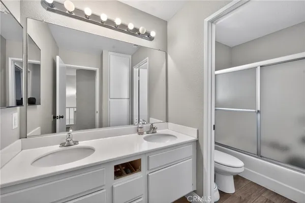 a bathroom with a double vanity sink toilet and a mirror