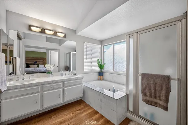 a bathroom with a double vanity sink mirror and bathtub