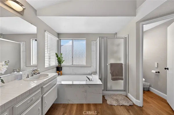 a spacious bathroom with a tub sink and mirror