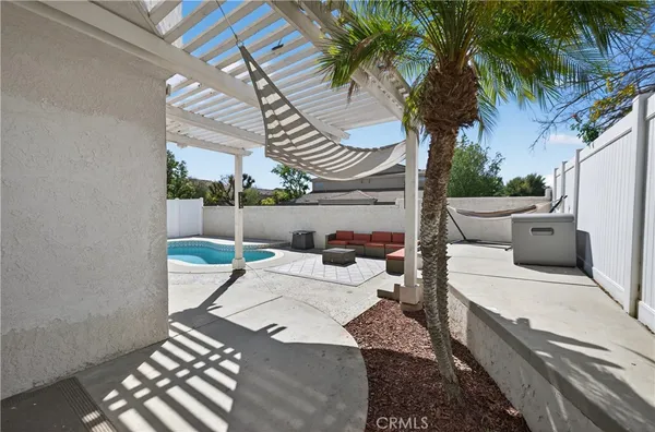 a view of a patio with table and chairs potted plants and palm tree