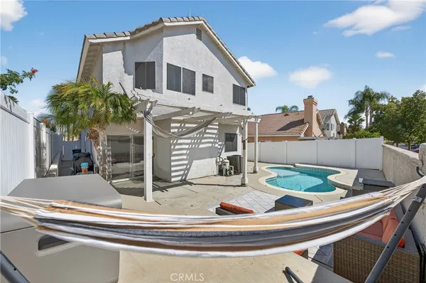 a view of a house with a swimming pool and furniture