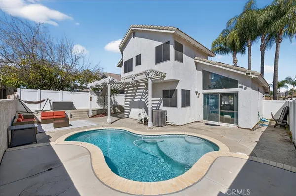a view of a house with swimming pool and sitting area