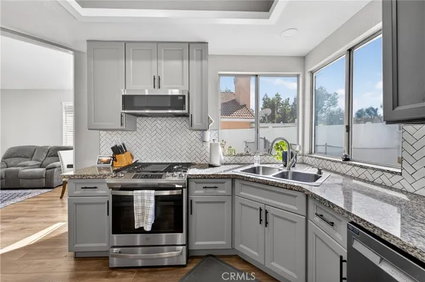 a kitchen with stainless steel appliances granite countertop a sink stove and cabinets