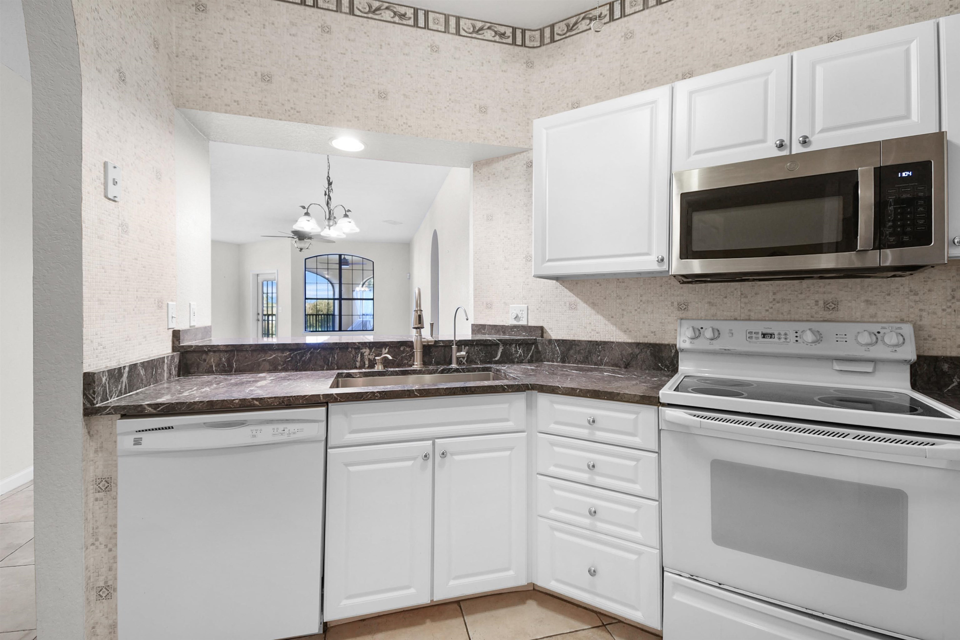 2221 Vista Cove Road St. Augustine, FL 32084 - Photo 7 of 30 a kitchen with granite countertop white cabinets white stainless steel appliances and a sink