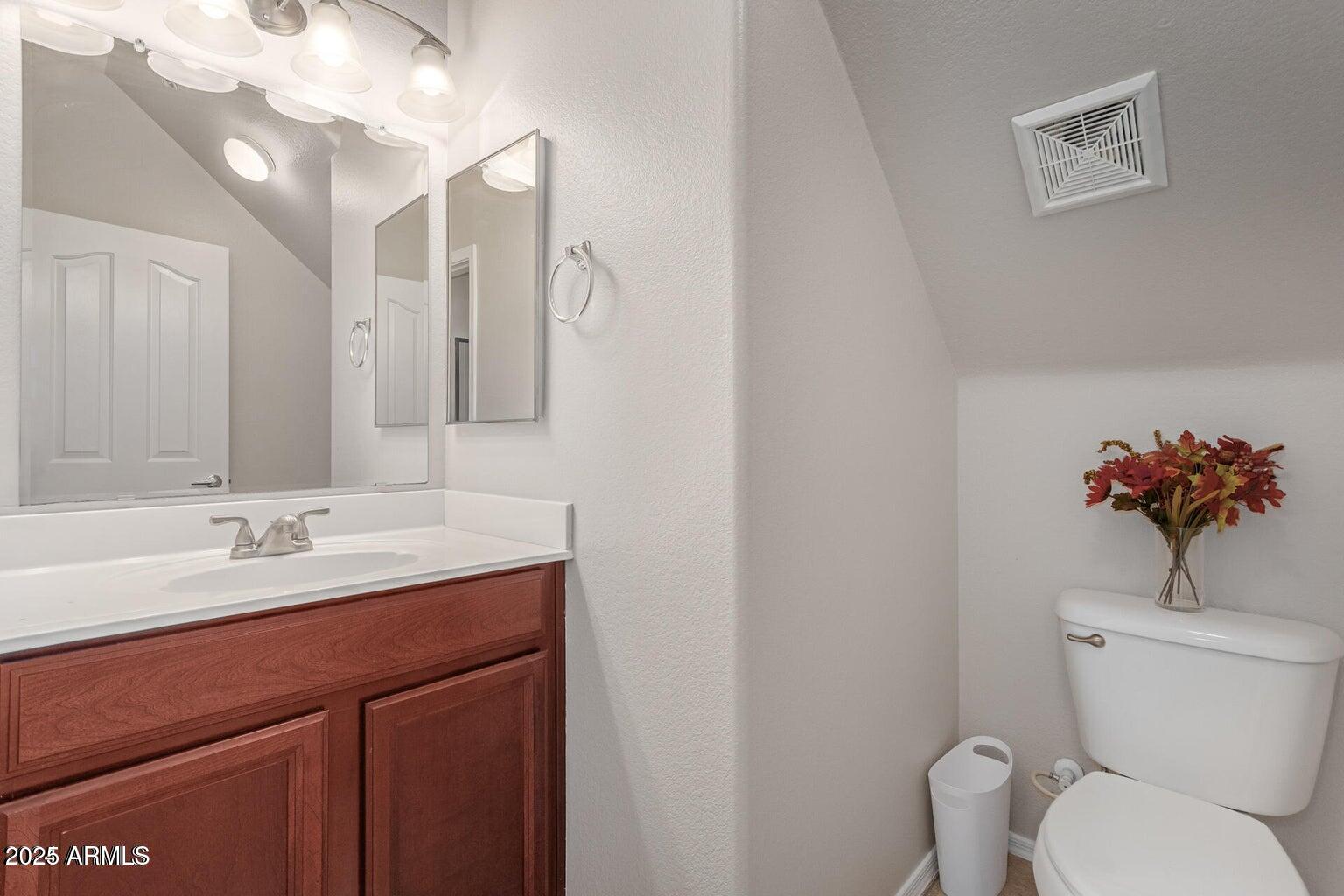 2402 East 5th Street, Unit 1402 Tempe, AZ 85288 - Photo 12 of 36 a bathroom with a toilet sink and mirror