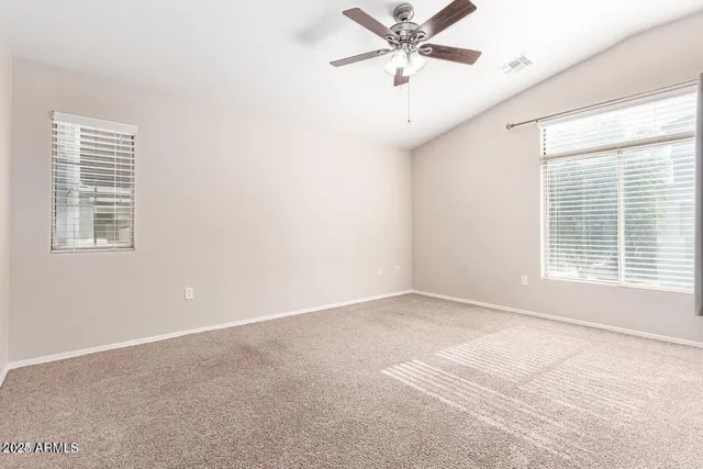 an empty room with a window and a fan