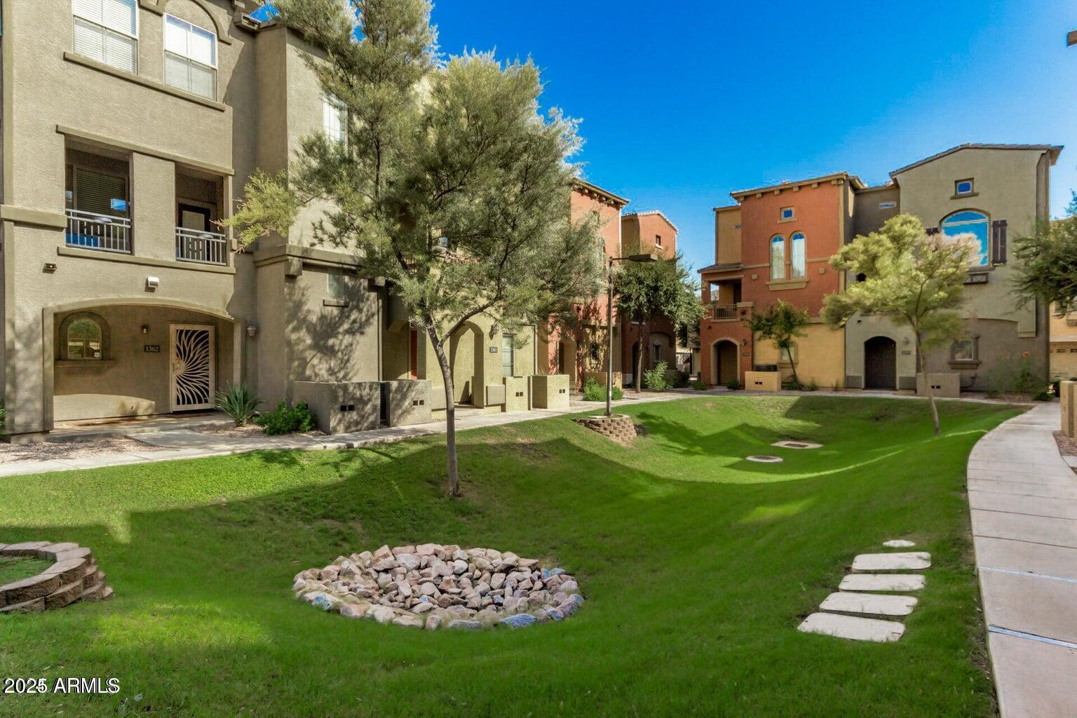 2402 East 5th Street, Unit 1402 Tempe, AZ 85288 - Photo 27 of 36 a view of a white house with a big yard and potted plants and large trees