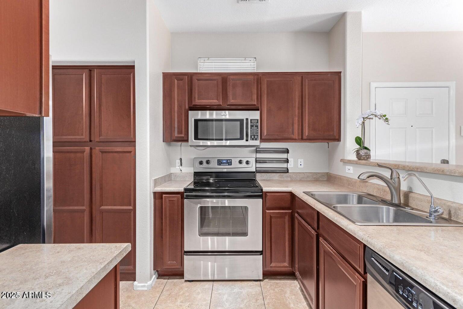 2402 East 5th Street, Unit 1402 Tempe, AZ 85288 - Photo 3 of 36 a kitchen with a sink stove and refrigerator