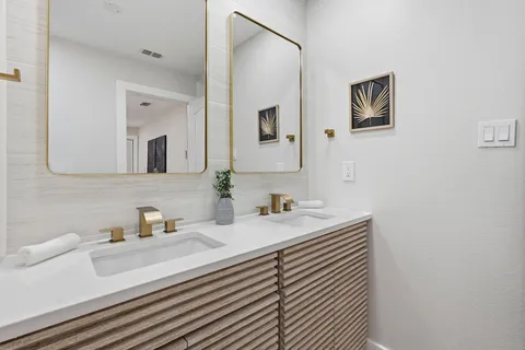a bathroom with double vanity sinks a mirror and a shower