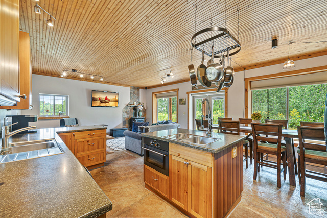 2029 West Tollgate Road Coalville, UT 84017 - Photo 12 of 43 Kitchen featuring wooden ceiling, brown cabinets, oven, a kitchen island with sink, and dark countertops