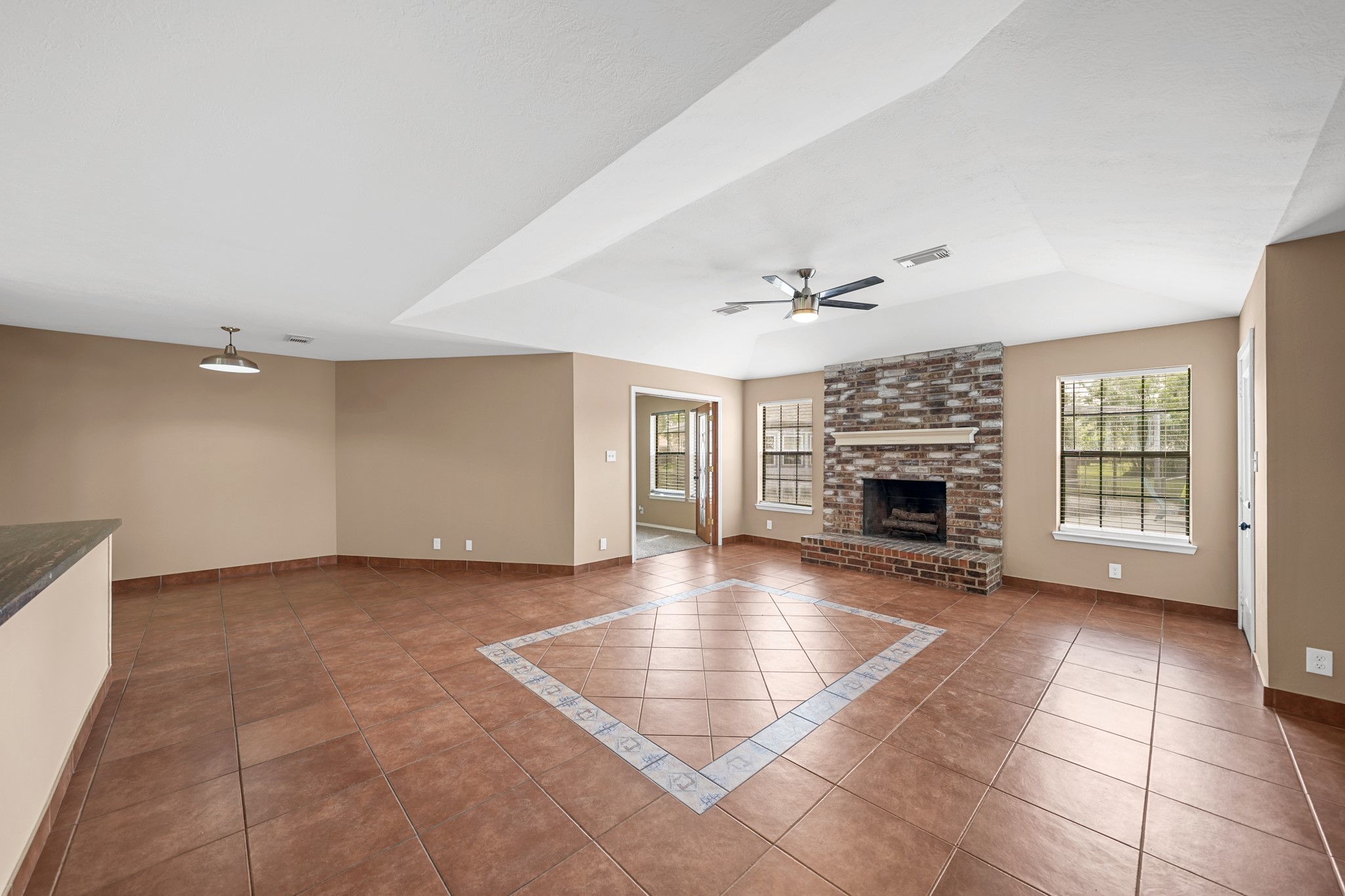 4435 South Tower Road Santa Fe, TX 77517 - Photo 9 of 35 The expansive living room showcases vaulted ceilings and a beautiful brick fireplace, creating a warm and inviting space to gather or unwind.