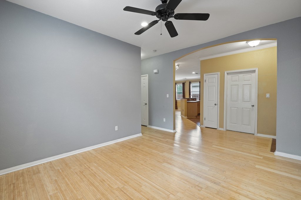 347 Spring Drive Kyle, TX 78640 - Photo 7 of 40 Natural wood flooring extends throughout this versatile living space, offering seamless transitions.