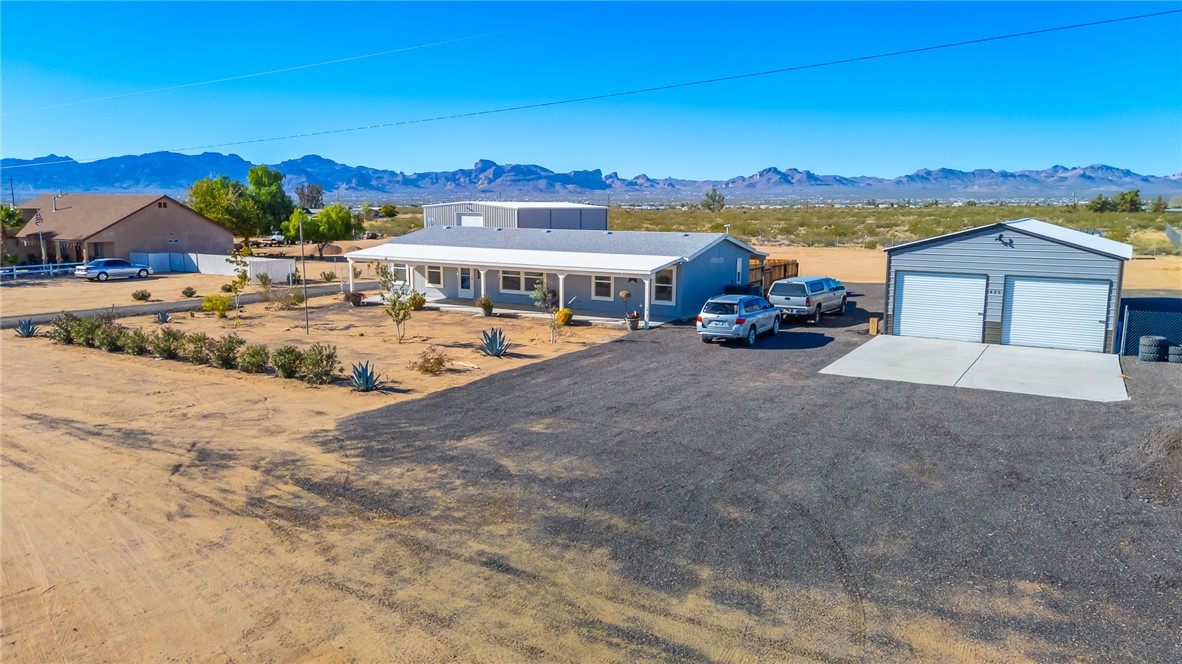 429 South Lochiel Road Golden Valley, AZ 86413 - Photo 1 of 61 View of front facade with a mountain view, an outdoor structure, a detached garage, driveway, and covered porch