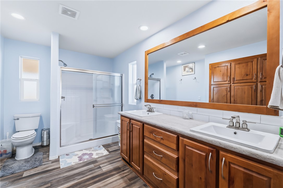 429 South Lochiel Road Golden Valley, AZ 86413 - Photo 5 of 61 Bathroom featuring a stall shower, double vanity, dark wood finished floors, and recessed lighting