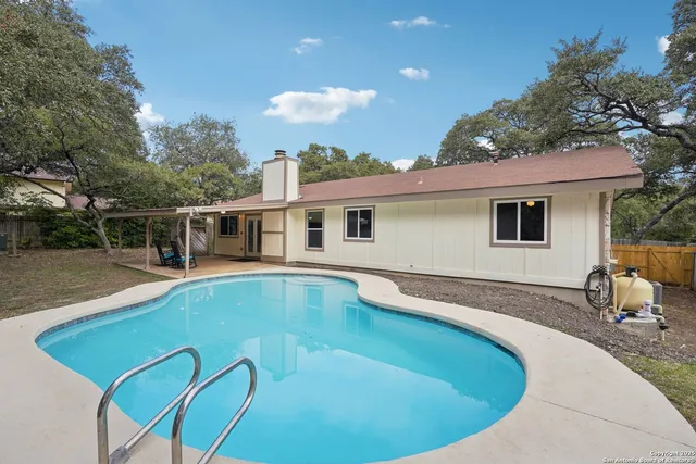 a view of a house with swimming pool and sitting area