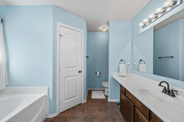 a bathroom with a tub 2 sink and mirror