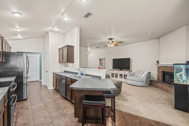 a large kitchen with stainless steel appliances granite countertop a stove refrigerator a sink dishwasher and microwave oven