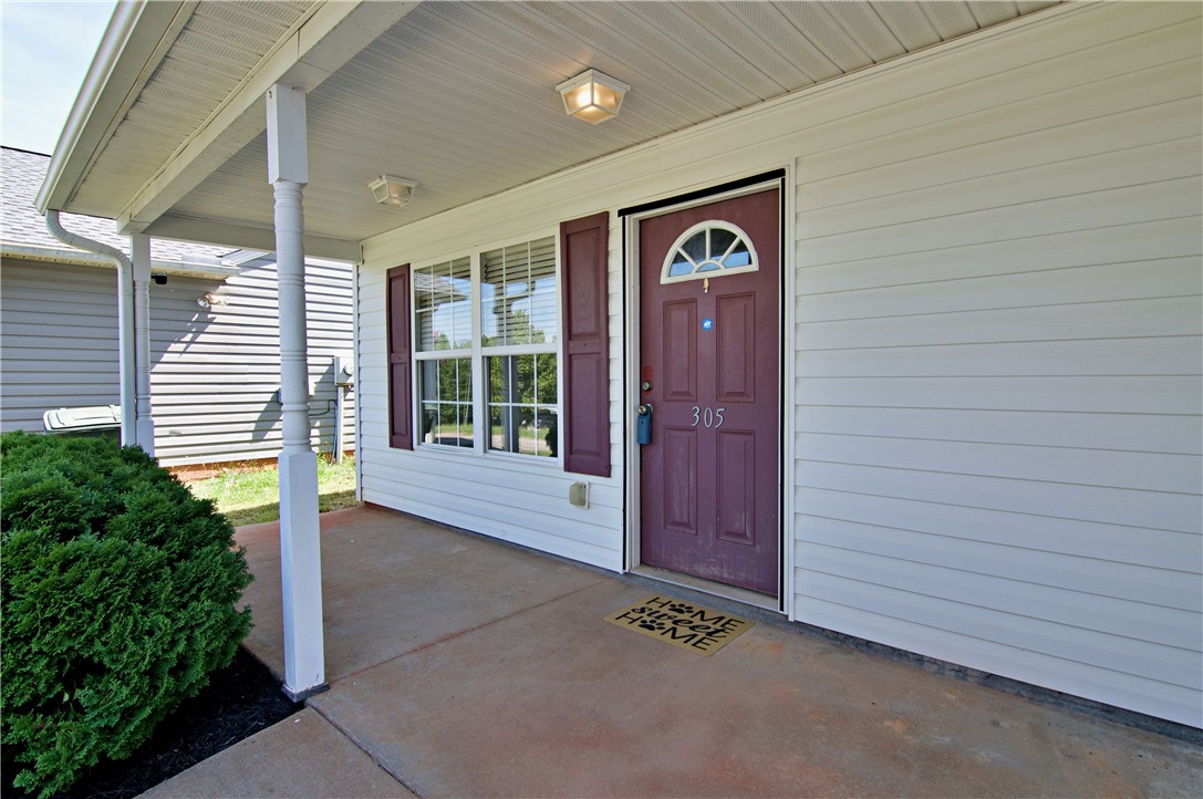 305 North Chestnut Street Seneca, SC 29678 - Photo 5 of 44 A welcoming covered porch with a vibrant door offers charming curb appeal.