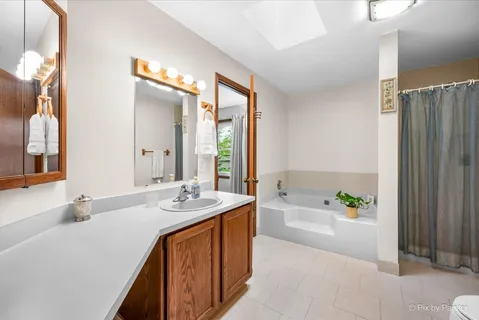 a spacious bathroom with a granite countertop tub sink and mirror