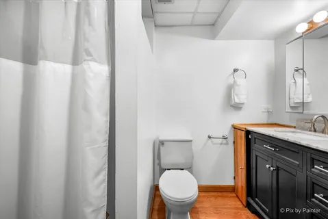a bathroom with a granite countertop toilet sink and mirror