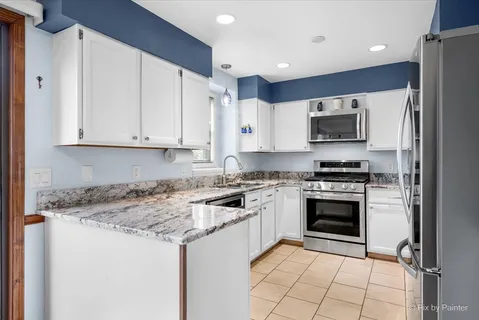 a kitchen with stainless steel appliances granite countertop a stove top oven a sink and a microwave
