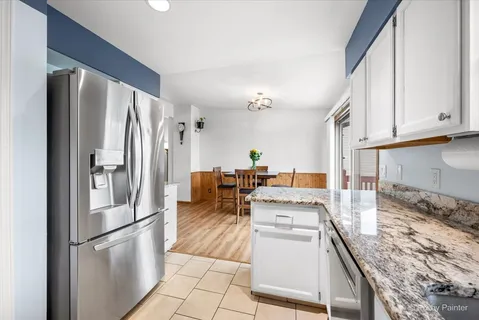 a kitchen with stainless steel appliances granite countertop a refrigerator a stove and a sink