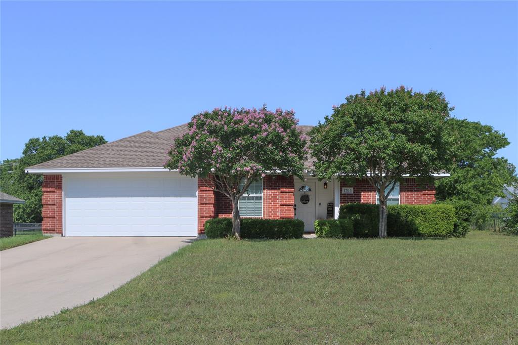 1705 North Cates Street Decatur, TX 76234 - Photo 1 of 1 Obstructed view of property with a front lawn, concrete driveway, brick siding, and a garage