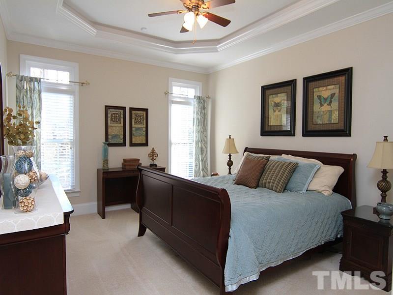 3201 Ringland Road Raleigh, NC 27613 - Photo 12 of 25 a bedroom with a bed and a chandelier
