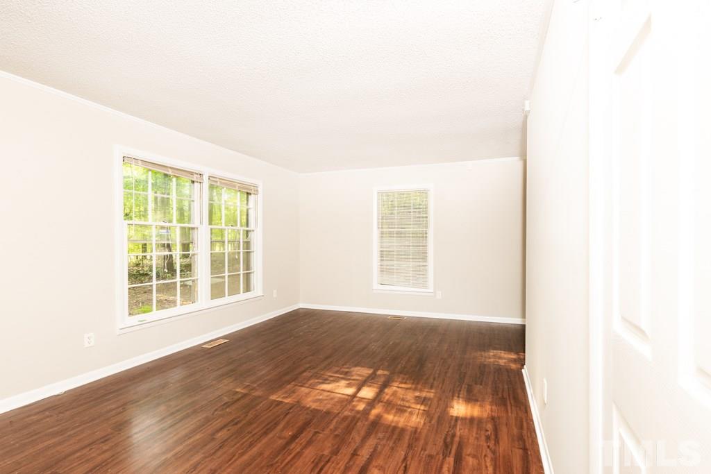 2705 Whitfield Road Chapel Hill, NC 27514 - Photo 2 of 15 a view of an empty room with wooden floor and a window