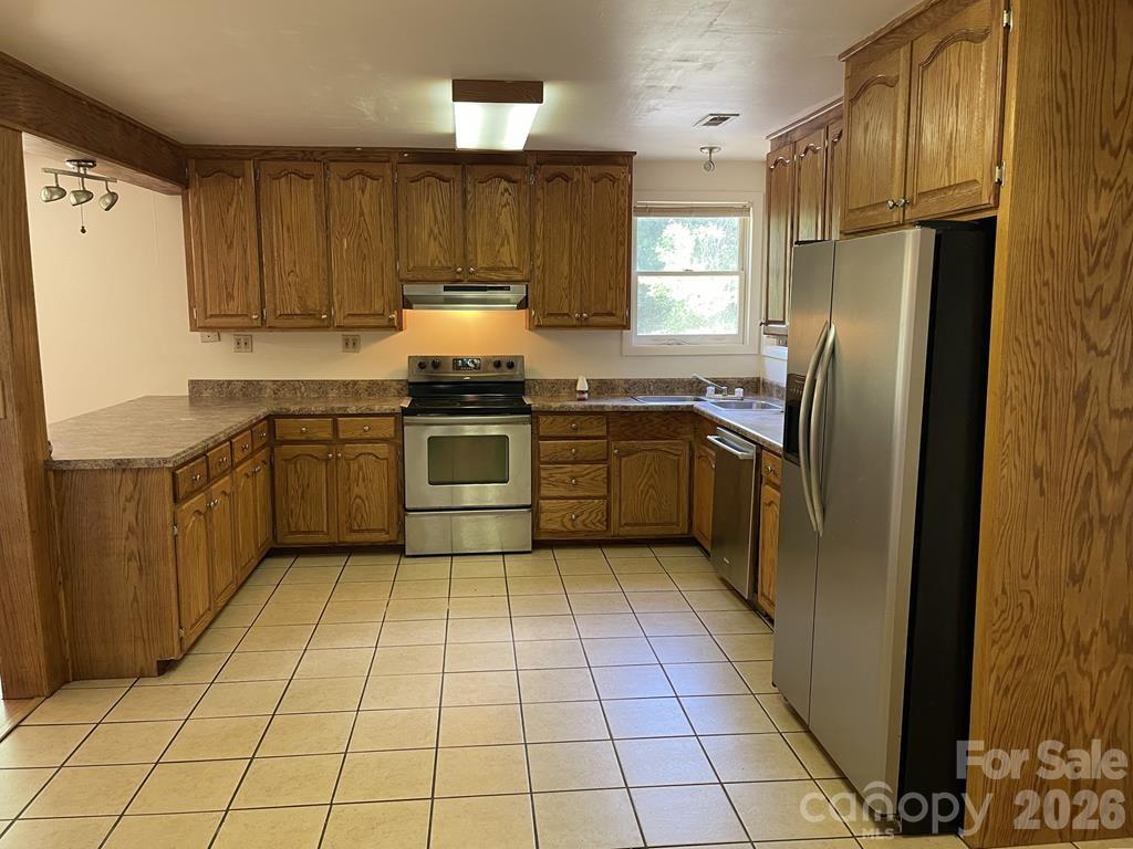 930 Copperhead Cove Road Sylva, NC 28779 - Photo 9 of 18 a kitchen with stainless steel appliances granite countertop a refrigerator sink and cabinets