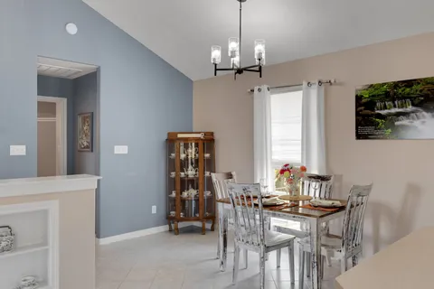 a view of a dining room with furniture and chandelier