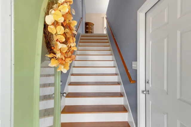 a view of staircase with wooden floor and white walls