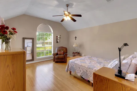 a bedroom with bed window and potted plant