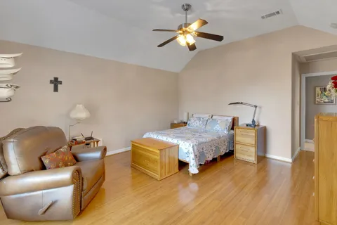 a bedroom with a bed furniture and wooden floor