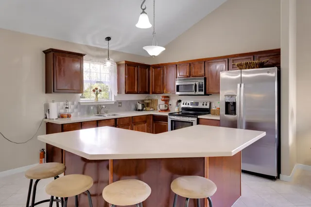 a kitchen with a table chairs refrigerator and microwave