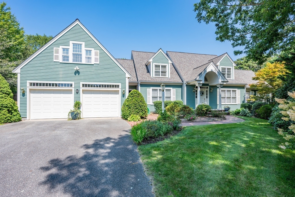 6 Match Point Dennis, MA 02638 - Photo 3 of 42 a front view of a house with a yard and garage