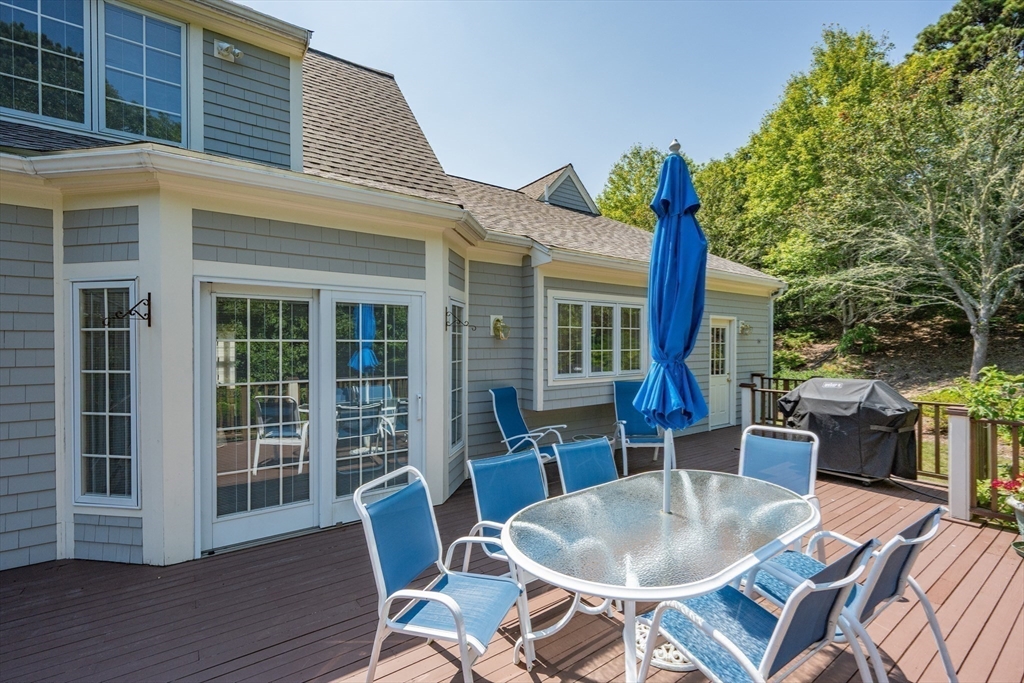 6 Match Point Dennis, MA 02638 - Photo 32 of 42 a view of a patio with table and chairs potted plants and floor to ceiling window and wooden floor